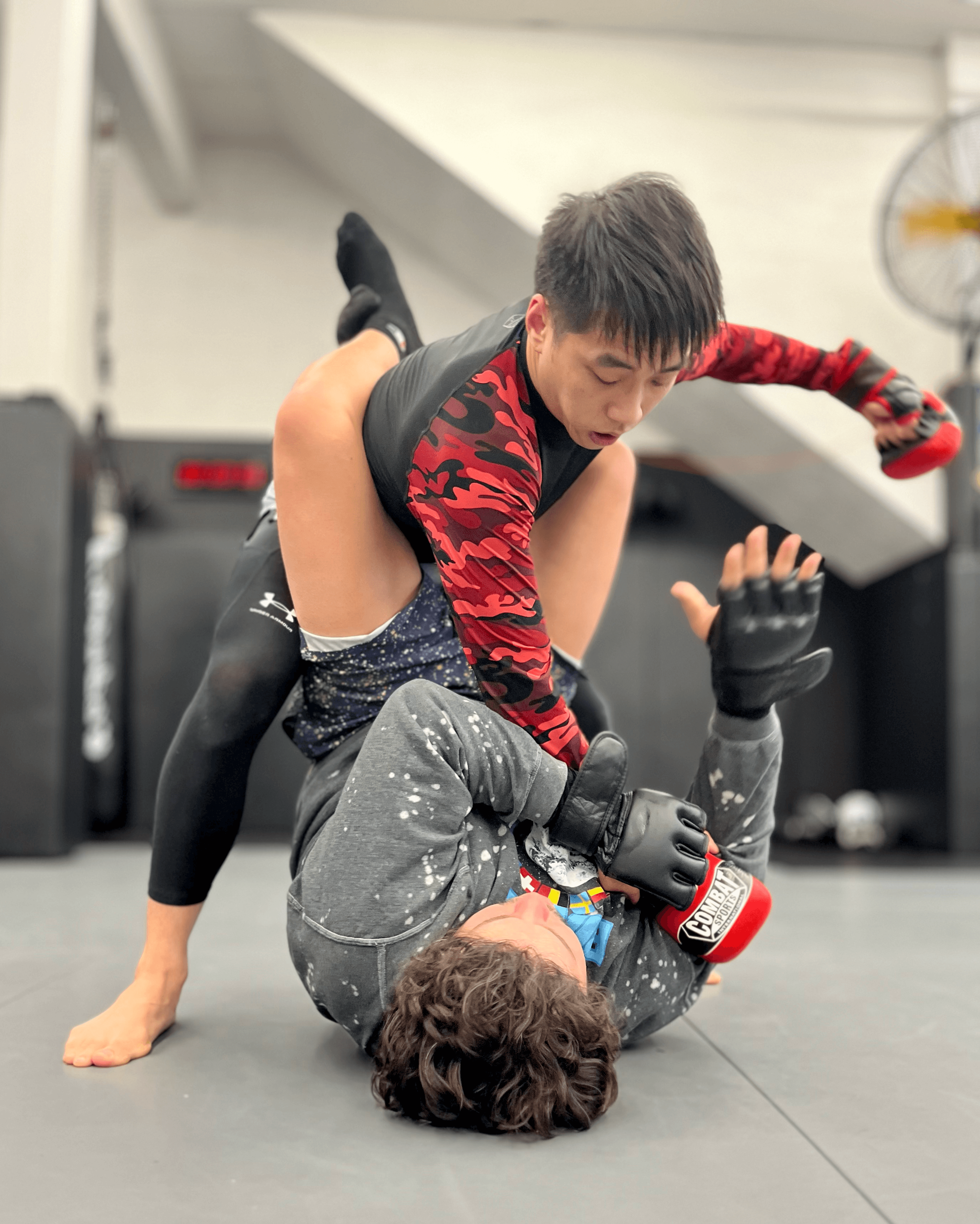 Two students practicing MMA ground game.